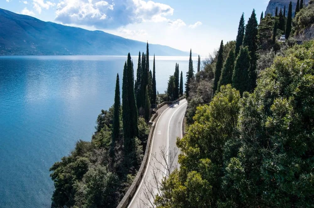 scenic road around lake Garda among trees and cypresses